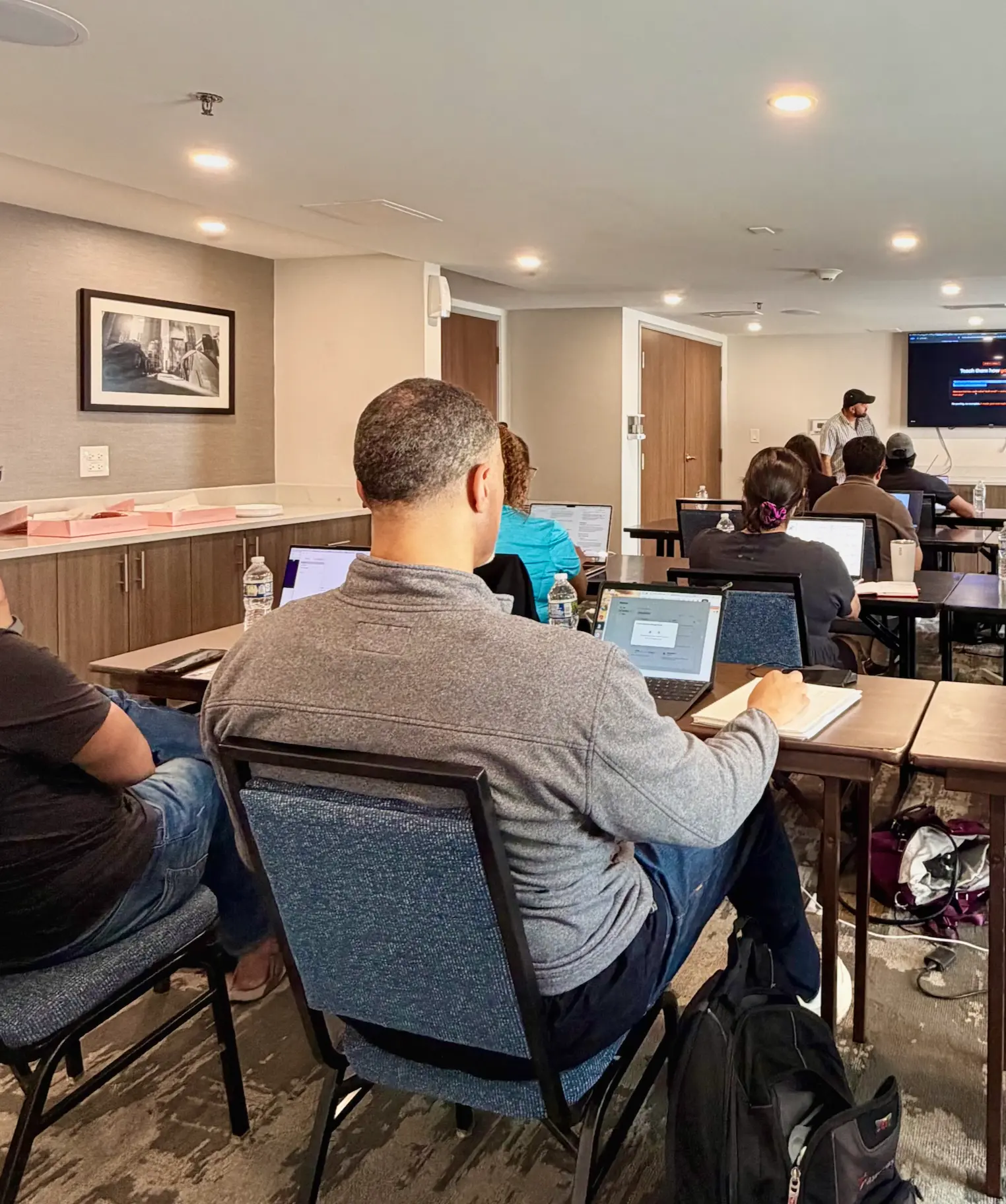 Full workshop room with attendees following along on laptops
